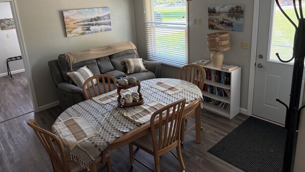 A dining area with a round table, chairs, and a bookshelf. - Relax in Waupaca and the Chain O Lakes. (Waupaca)