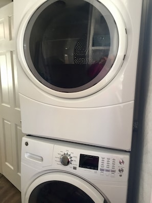 A stacked washer and dryer unit with control panels and a door.