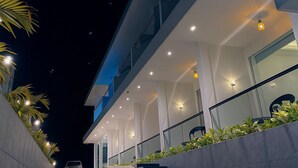 Un edificio moderno con una escalera que conduce a un balcón con plantas.
