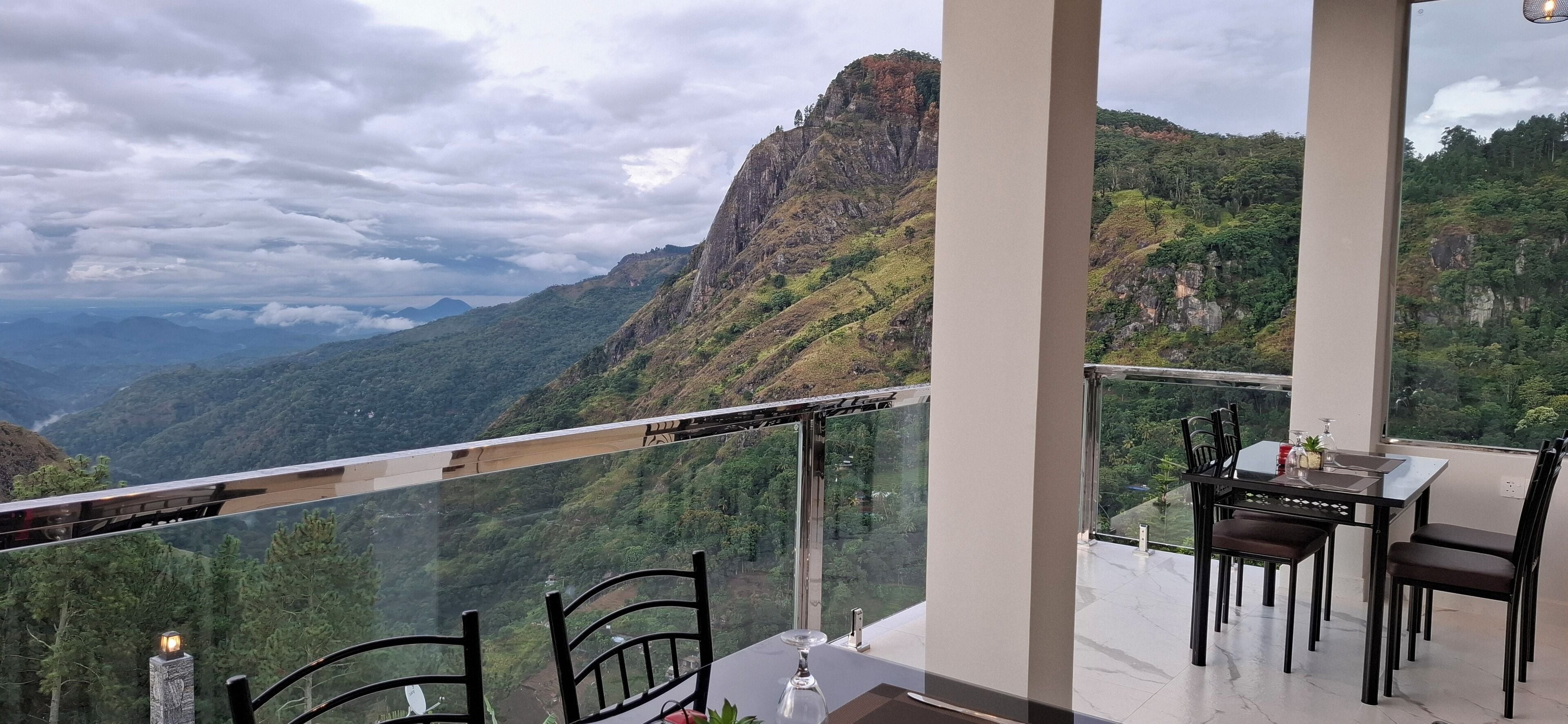 Un comedor con mesa y sillas, con vista a un paisaje montañoso y una perspectiva despejada del valle y las montañas al fondo.