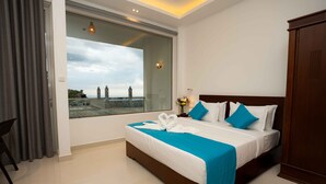 Un hotel moderno con una cama grande, vistas a la ciudad y un balcón.