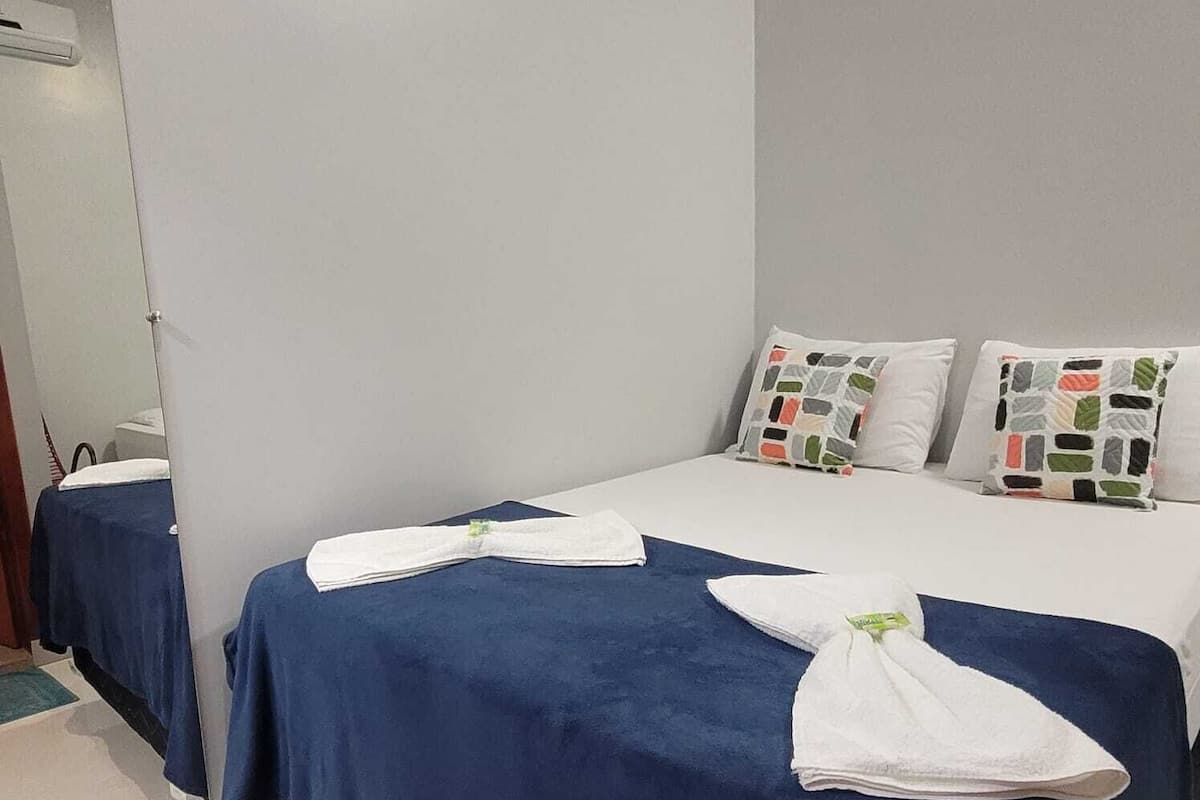 Ett hotellrum med två sängar, var och en med ett blått överkast och vita kuddar.