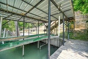 Un espacio al aire libre cubierto con cubierta de madera, vigas de metal y una fuente de agua.