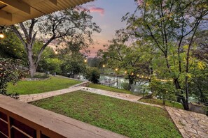 Un jardí paisatjístic amb una bassa, senders de pedra i llums lluminoses.