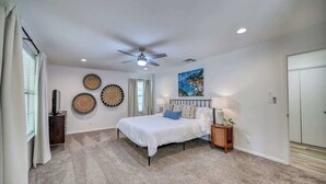 A bedroom with a bed, ceiling fan, wall decor, and a window. - Lakefront Near Schlitterbahn and New Braunfels (McQueeney)