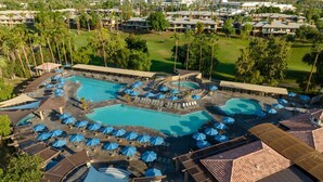 Um resort com várias piscinas, espreguiçadeiras e guarda-sóis.