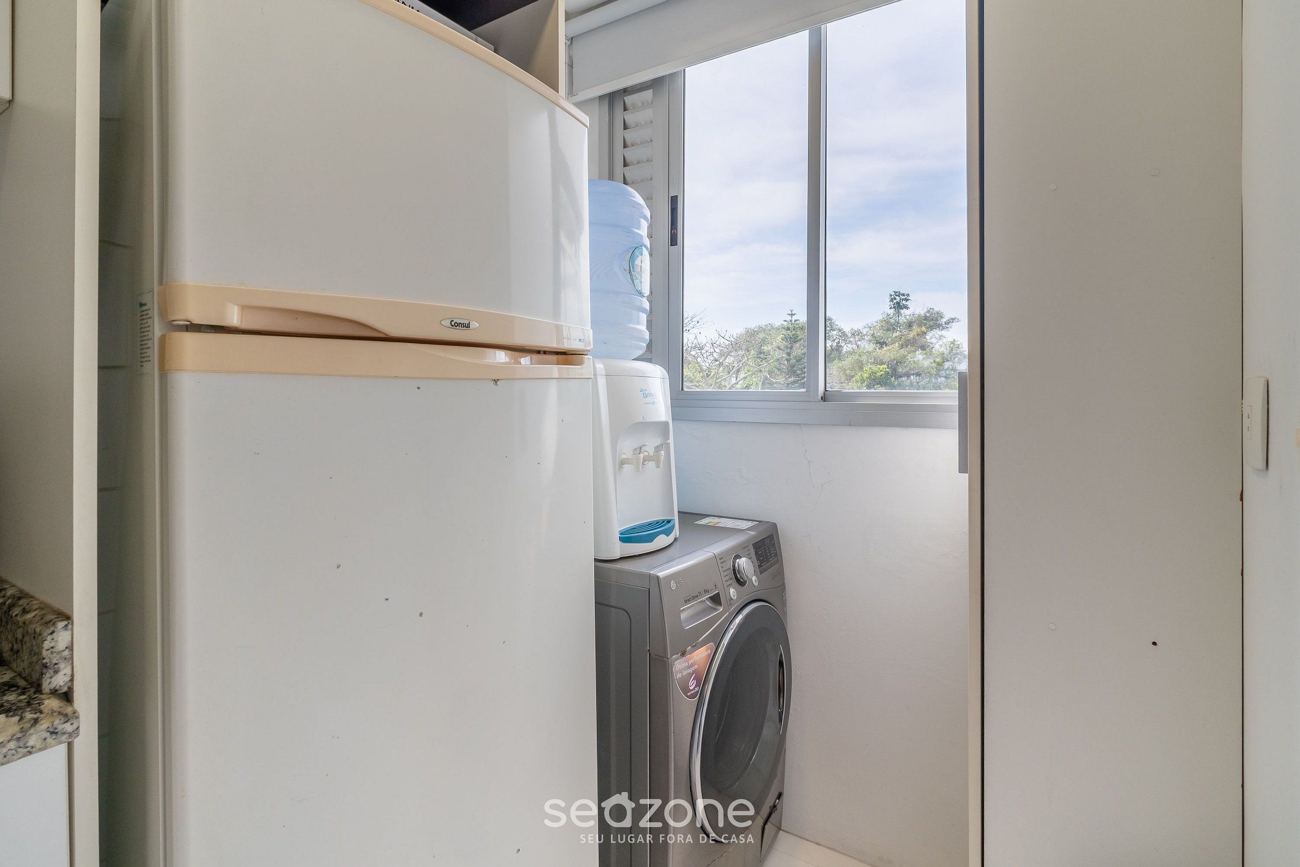 A laundry area with a washing machine and a water dispenser.