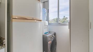 A laundry area with a washing machine and a water dispenser.