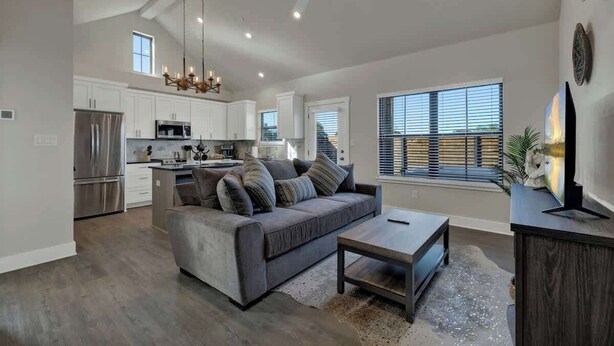 A spacious living area with a gray sofa, a coffee table, and a ceiling fan.