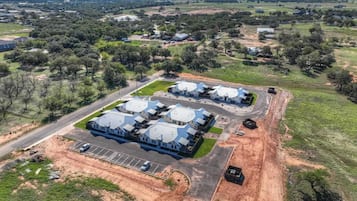 An aerial view of a residential area with multiple houses and a parking lot.