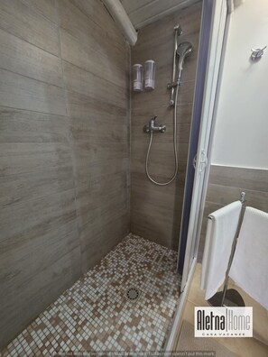 A shower area with tiled walls and floor, a handheld showerhead, and a wall-mounted faucet. - ALETNA HOME vacation home (Ragalna)