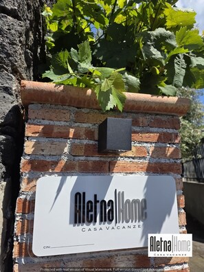A brick wall with a sign for 'Aletna Home CASAVACANZE'. - ALETNA HOME vacation home (Ragalna)
