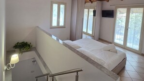 A bedroom with a wooden ceiling, a bed, a window, and a balcony.