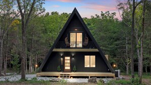 A modern A-frame cabin with a balcony, surrounded by forest. - Luxury A-Frame*Hot-tub*Firepit (Omaha)