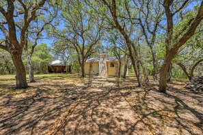 Un chalet rustique entouré d’arbres, sous un ciel dégagé.