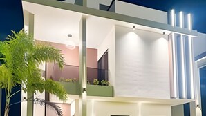 A modern two-story house with a well-maintained lawn, a pathway leading to the entrance, and a balcony with potted plants. - Family Villa in Punta Cana! Heated Pool (Punta Cana)