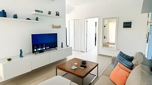 Ein modernes Wohnzimmer mit Flachbildfernseher, Couchtisch und Sofa.
