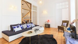 Una sala de estar moderna con un sofá, una mesa de centro, un televisor y una chimenea.