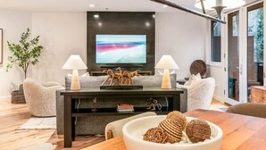 A modern living room with a flat-screen TV, two lamps, a bowl of snacks, and a sofa. - The Ice House: Luxury & Location w/ pool & hot tub (Telluride)