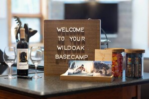 A welcome sign, wine bottle, glasses, and jars on a counter. - The Ice House: Luxury & Location w/ pool & hot tub (Telluride)