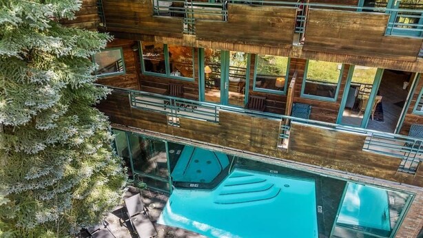 A multi-story wooden building with balconies, a swimming pool, and outdoor seating. - The Ice House: Luxury & Location w/ pool & hot tub (Telluride)