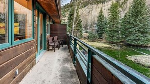 A wooden cabin with a balcony overlooking a forested area and a body of water. - The Ice House: Luxury & Location w/ pool & hot tub (Telluride)
