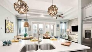 A modern kitchen with a large island, stainless steel appliances, and pendant lighting. - 5 Mins from Beach with Private Golf Cart and Pool (Santa Rosa Beach)