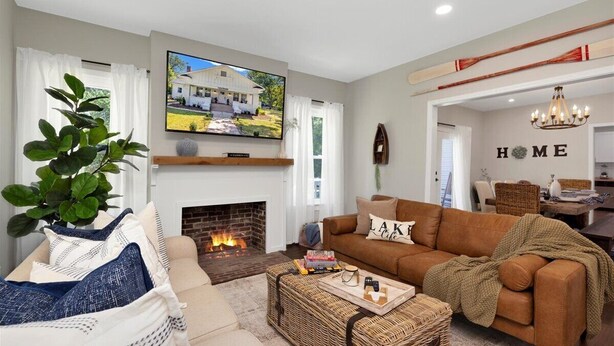 A living room with a fireplace, a television, a sofa, and a coffee table. - Peaceful Lake House - Sleeps 10, Games, Fishing & Near Downtown/Airport/BJCC (Birmingham)