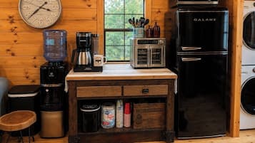 Une cuisine compacte équipée d’un réfrigérateur Galanz, d’une machine à café, d’un four à micro-ondes et d’un distributeur d’eau.