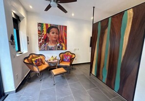 Un salon moderne agrémenté d’un grand tableau abstrait, de fauteuils en cuir et d’un mur d’accent en bois.
