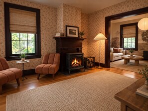 Una sala de estar acogedora con chimenea, dos sillones, un sofá y una mesita de centro.