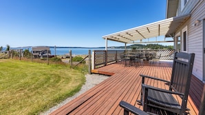 Un ponte di legno con arredi da esterno, una zona relax coperta e vista sull'oceano.