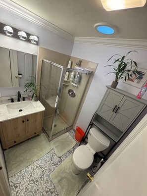 A bathroom with a shower, toilet, sink, and cabinet. - Posh 4BD3BA - 2 Living Rooms - Gameroom - Patio - BART - Walk to Grocery (Concord)