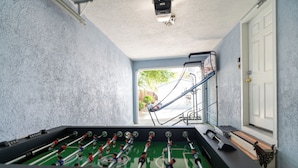 Un tavolo da calcio d'aria in una stanza con una porta e una finestra.