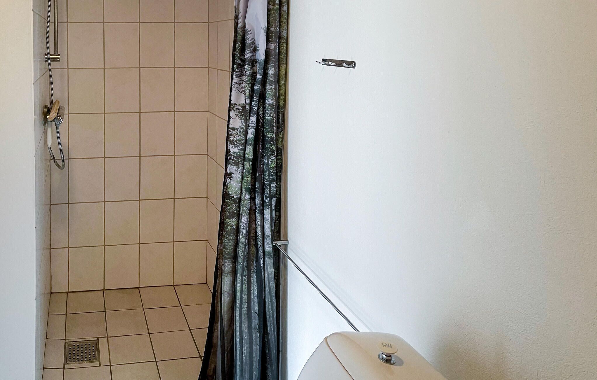 Une salle de bain avec une douche, des toilettes et un lavabo.
