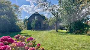A house with a sloped roof, surrounded by a well-maintained lawn and trees. - Amazing home in Stolwijk with house sea view (Stolwijk)