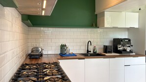 A modern kitchen with white subway tiles, a gas stove, a coffee machine, and a toaster. - Amazing home in Stolwijk with house sea view (Stolwijk)