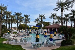 A pool area with lounge chairs, umbrellas, and palm trees. - Stunning Golf Course Home!!!   November 2025 available!!! (Surprise)