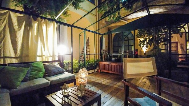 An outdoor seating area with a wooden table, two chairs, a sofa, and a lantern. - 2 bedroom beautiful home in Cava de' Tirreni (Cava de' Tirreni)