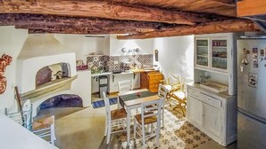 A compact kitchen with white cabinets, a built-in oven, and a refrigerator. - 2 bedroom beautiful home in Cava de' Tirreni (Cava de' Tirreni)