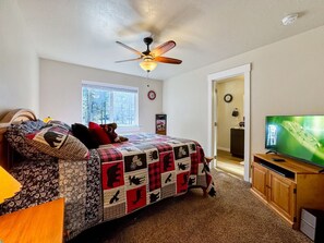 A bedroom with a bed, a ceiling fan, a television, and a window. - Modern Retreat Near Boulder Creek & Lake Cascade (Donnelly)