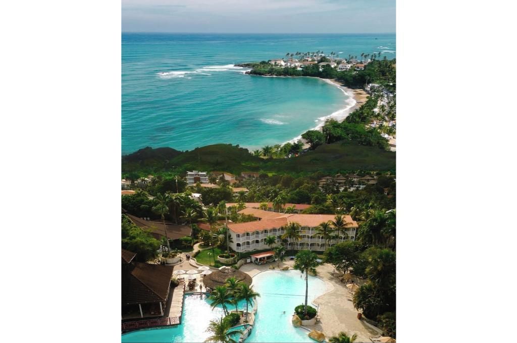 A resort with a large pool, beachfront, and ocean views.