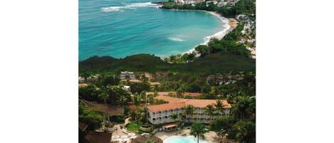 Ein Resort mit großem Pool, direkt am Strand und Blick auf den Ozean.
