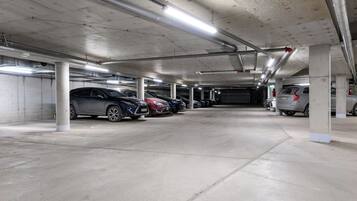Un parking à plusieurs niveaux, doté de piliers en béton et d’un éclairage au plafond.
