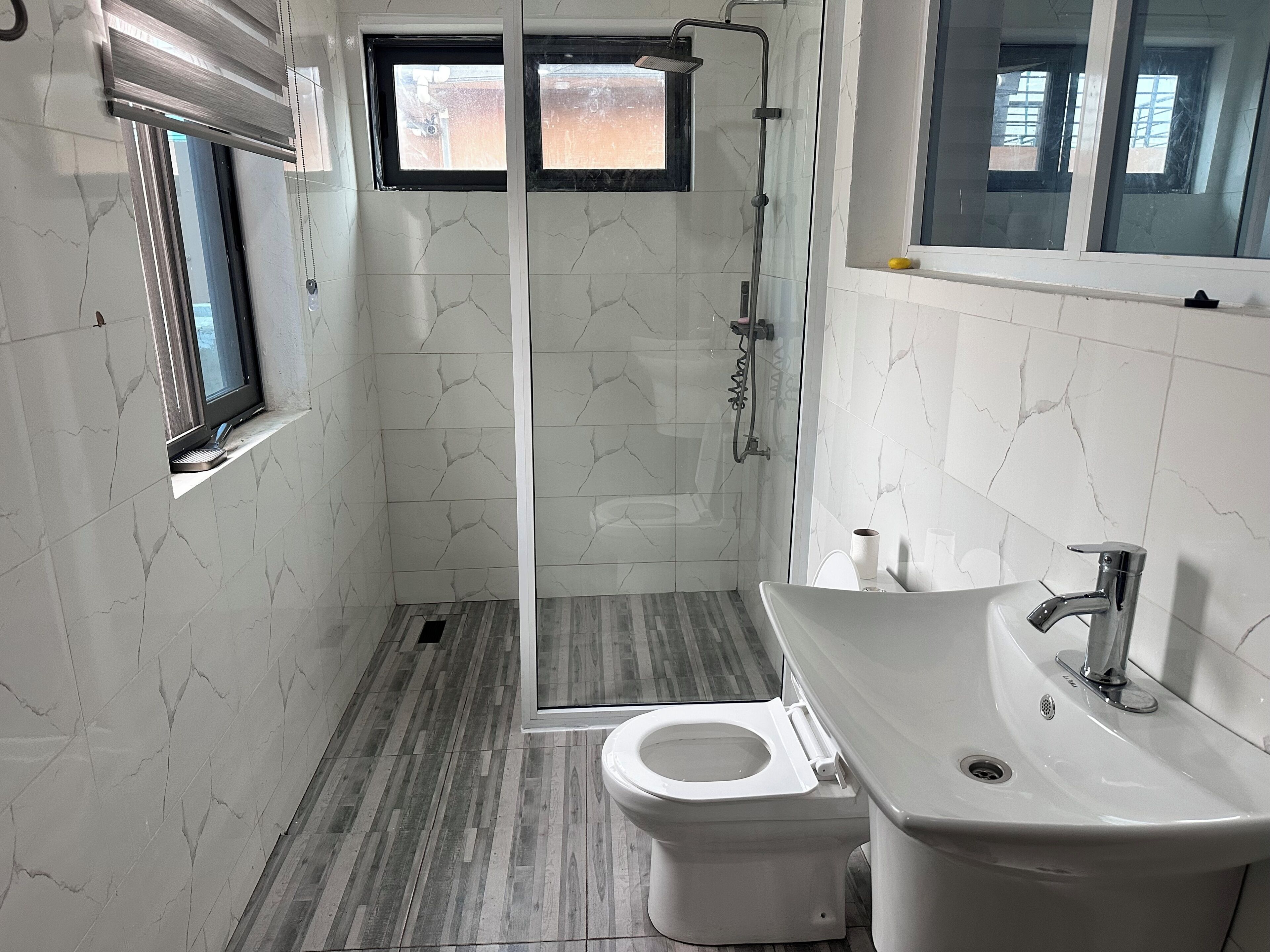 A bathroom with a shower, toilet, and sink.