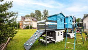 A playground with a slide and climbing structures in a grassy area.