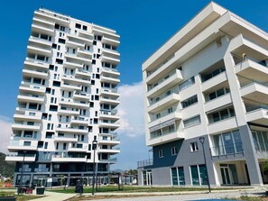 Um edifício moderno de vários andares com varandas e grandes janelas.