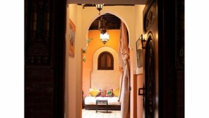 A narrow hallway leading to a bedroom with a bed, a nightstand, and a small table. - 5-bedroom bed & breakfast in phenomenal Marrakech with AC (Marrakech)