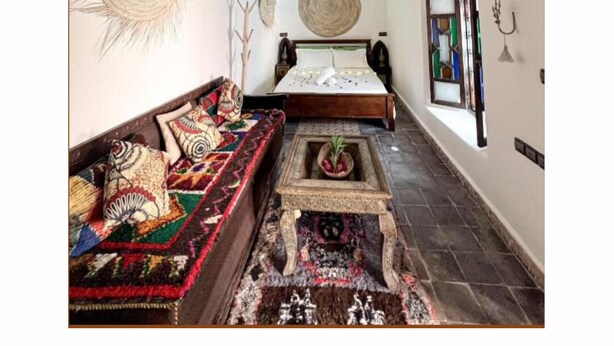 A room with a bed, a sofa, a woven ceiling light, and a decorative wall piece. - 5-bedroom bed & breakfast in phenomenal Marrakech with AC (Marrakech)