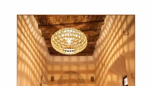 A narrow room with a bed, a colorful rug, and a hanging light fixture. - 5-bedroom bed & breakfast in phenomenal Marrakech with AC (Marrakech)